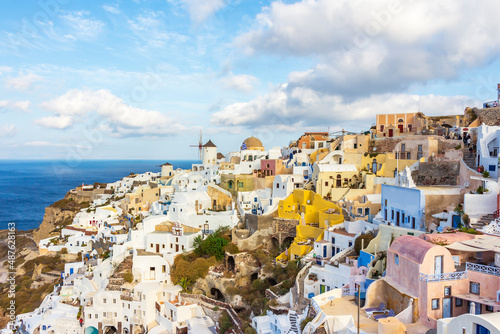 houses and windmills in the city of Thira, Santorini, Greek Islands. In the background the Aegean Sea