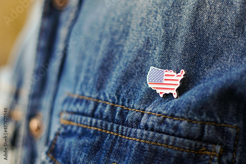 United State of America pin is pinned on blue jeans jacket. USA patriotism concept.