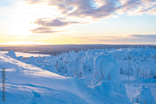 Winter landscape of a frosty morning in Lapland. Snow-covered forest, trees covered with snow and deep snow with snowdrifts.