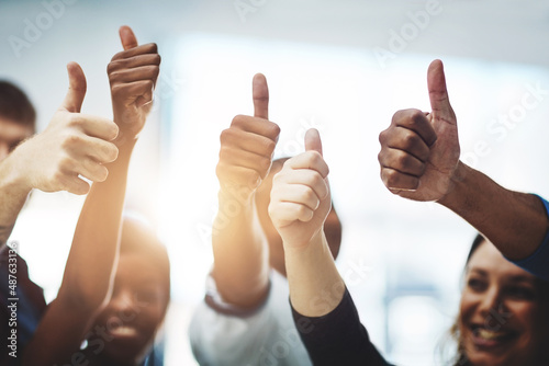 Bravo on your business accomplishment. Cropped shot of a team of colleagues showing thumbs up at work.