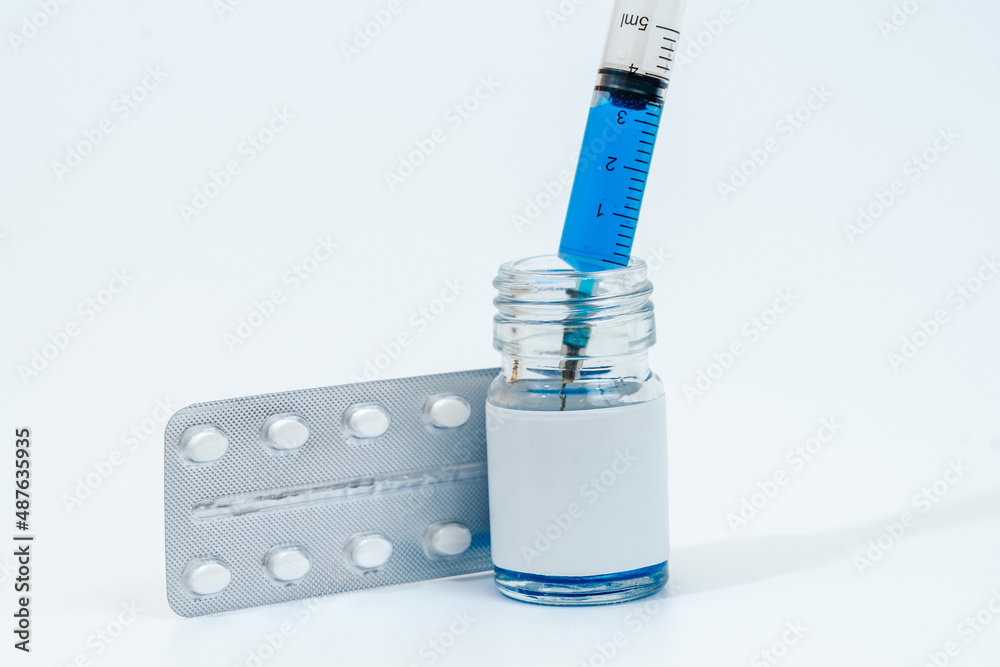 Medical glass bottle with syringe and tablets (pills) isolated on white background Medical glass bottle with syringe and tablets (pills) isolated on white background