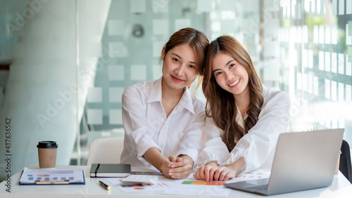 Two pretty Young Asian businesswoman or intern who sitting smile happily in the office. Looking at camera