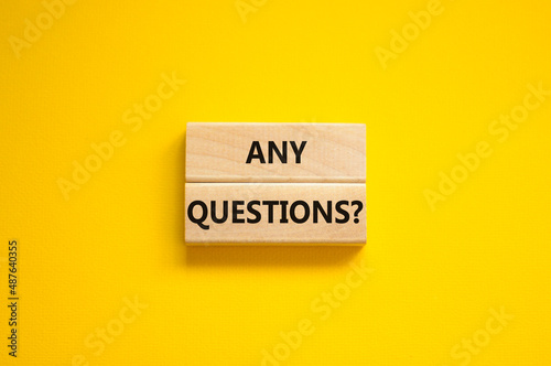 Any questions symbol. Concept words Any questions on wooden blocks on a beautiful yellow table yellow background. Business and Any questions Q and A concept, copy space. photo