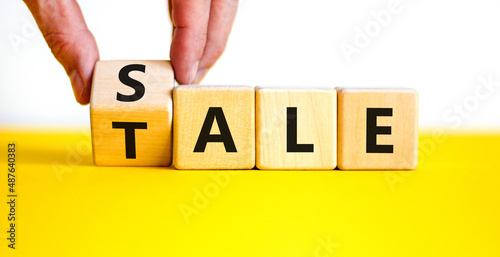 Sale or tale symbol. Businessman turns a wooden cube and changes the concept word Tale to Sale. Beautiful yellow table white background, copy space. Business and sale or tale concept. photo