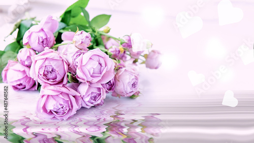 bouquet of pink flowers on a lilac background with hearts. A greeting card for congratulations on Mother's Day, Valentine's Day or an invitation to a wedding