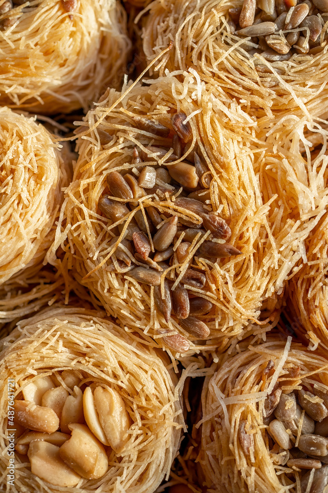 Baklava dessert with roasted peanuts from crushed filo dough in the shape of a bird's nest. Food background, oriental sweets close-up Baklava dessert with roasted peanuts from crushed filo dough in the shape of a bird's nest. Food background, oriental sweets close-up