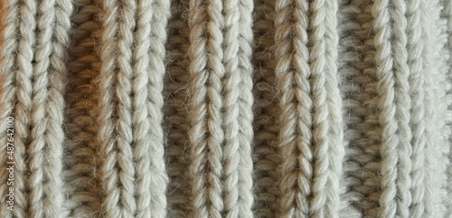 large knitting needles. texture with gray woolen threads. background for the design. the pattern is in braids.