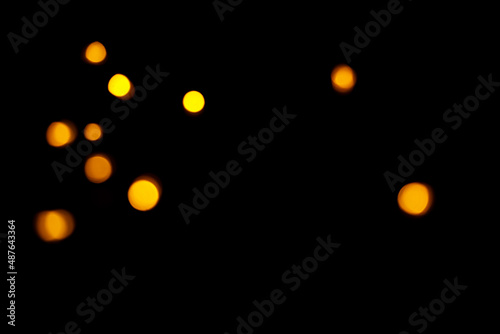 Gold bokeh on dark background. Defocused golden lights. New Year, Christmas background, abstract texture