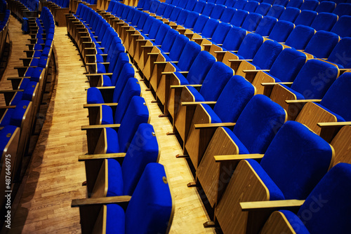
auditorium without people with blue chairs