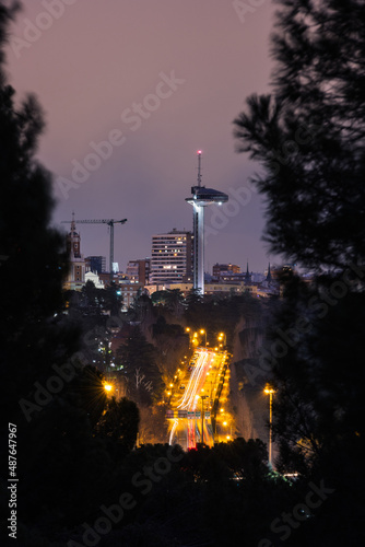 Fotografie Trail of lights leading to Madrid Faro de Moncloa watchtower at dusk, as seen from the Casa de Campo public park