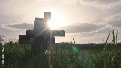 Two wooden christian cross in cemetery, sun rays shine behind, green grass, love after death, past and future, conceptual, hope photo