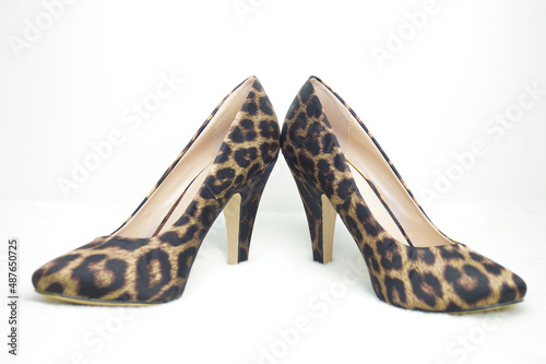 Leopard-colored shoes on a white background. Selective focus.