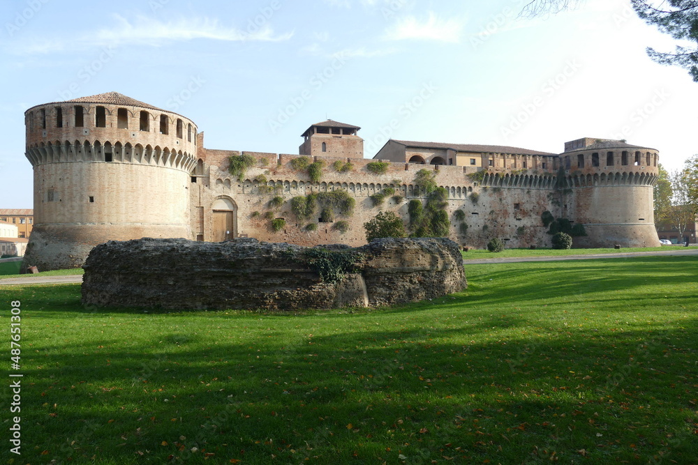 Sforza Castle in Imola, rear of the main building with ravines sorrouded by circular bastions and a green lawn with ruins in front
