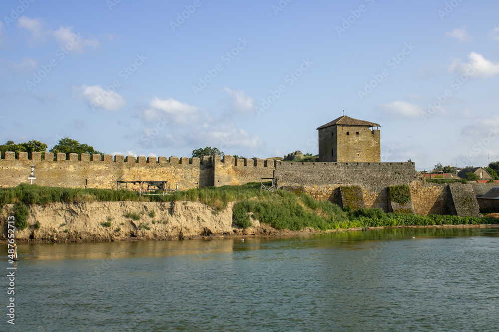 View of the defensive medieval fortress from the sea against the blue sky. Ancient citadel and towers of the fortress walls. Archaeological excavations of the historical bastion Akkerman.