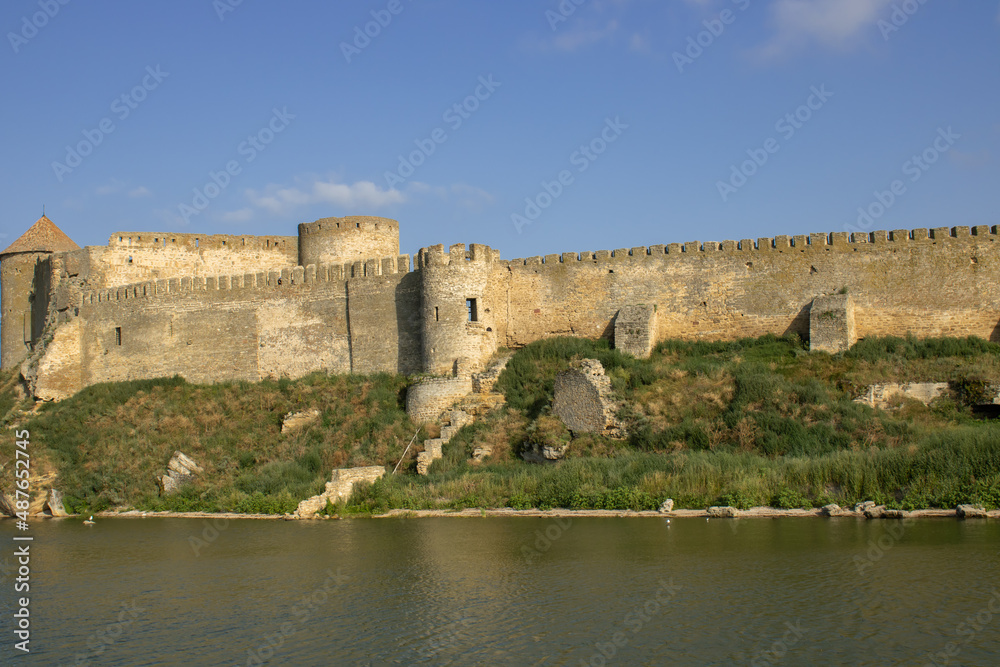 View of the defensive medieval fortress from the sea against the blue sky. Ancient citadel and towers of the fortress walls. Archaeological excavations of the historical bastion Akkerman.