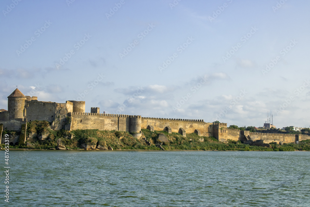 View of the defensive medieval fortress from the sea against the blue sky. Ancient citadel and towers of the fortress walls. Archaeological excavations of the historical bastion Akkerman.