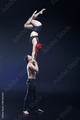 Circus acrobats man and woman showing tricks isolated on black background © Naz