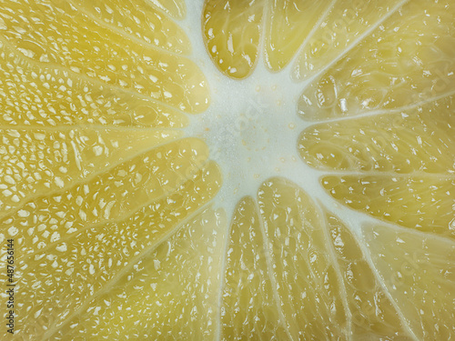 a slice of juicy fresh yellow aromatic bergamot very close in detail close-up macro. fruit background. pattern. photo