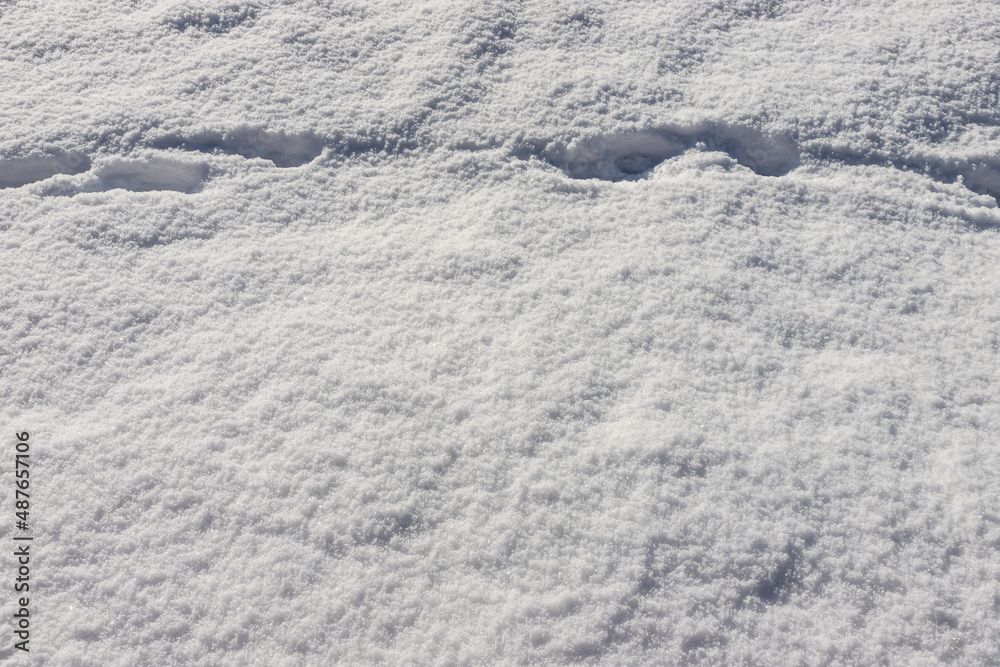 Beautiful winter background with snowy ground. Natural snow texture. Wind sculpted patterns on snow surface Beautiful winter background with snowy ground. Natural snow texture. Wind sculpted patterns on snow surface