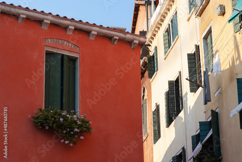 Fototapeta Naklejka Na Ścianę i Meble -  Window on red building with potted plants, Venice, Italy