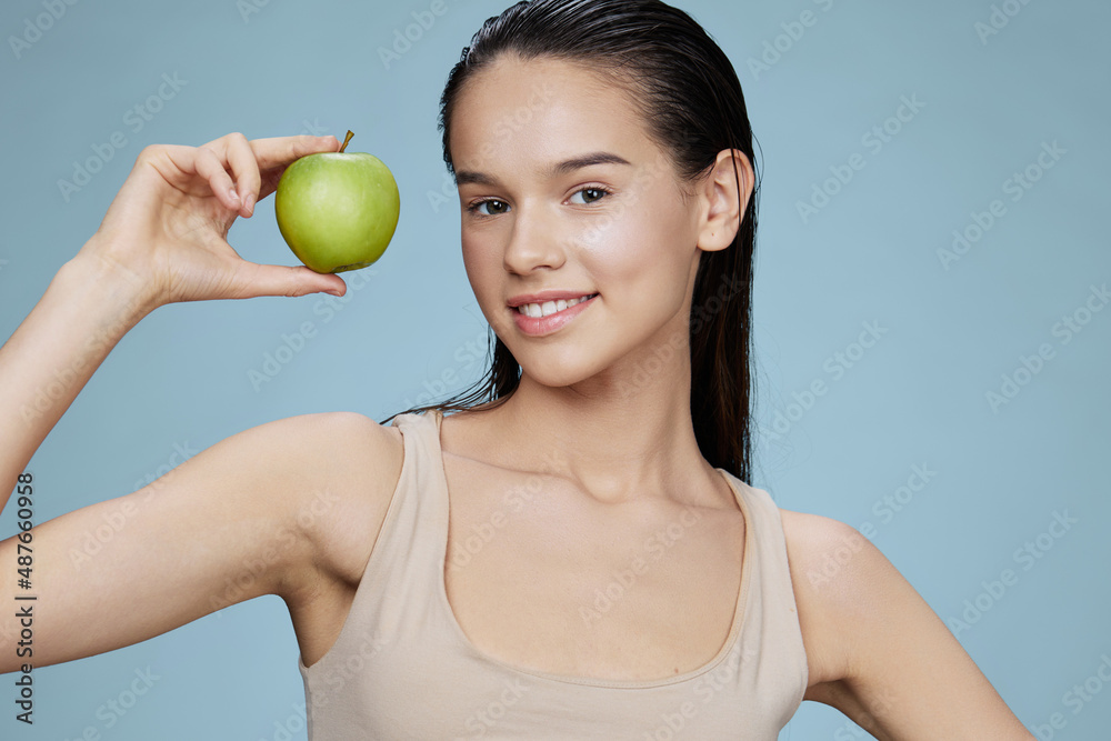 portrait woman with a green apple smile blue background portrait woman with a green apple smile blue background