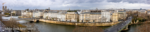 Seine embankment in Paris. View of the island Saint-Louis, the bridge de la Tournelle and Sully Bridge. Beautiful breathtaking panoramic cityscape of the majestic famous ancient French city.