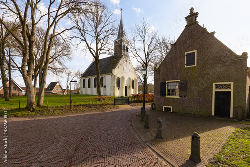 Former town hall and white 17th-century church in the Dutch village Groet on the North Sea coast. photo