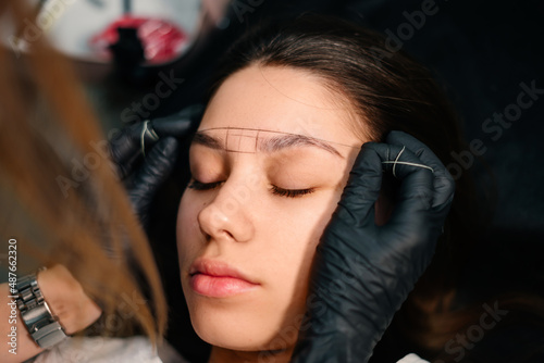Beauty masters hands do permanent eyebrow makeup. Minimal trauma to skin. Eyebrow microblading is performed using manipulator handle and special nozzle with needles. Cosmetologist skill level