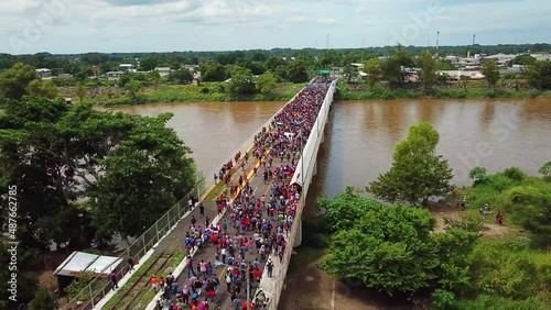 Una caravana de miles de migrantes de Honduras cruza el Puente Rodolfo Robles, un puente que pasa sobre el río Suchiate, una frontera natural de agua entre Guatemala y México, en octubre de 2018. photo