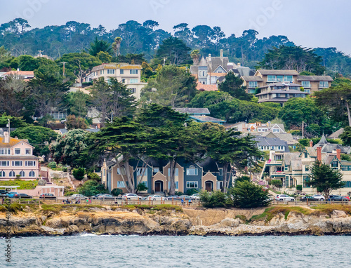 Houses in Pacific Grove, California (in Monterey County) overlook the rocky coastline, as viewed from a passing boat.