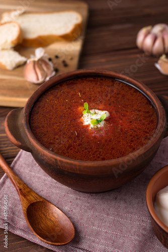 red beetsoup, traditional ukrainian borshch and garlic, wooden spoon photo