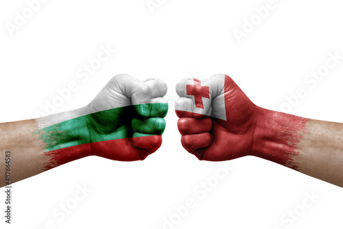 Two hands punch to each others on white background. Country flags painted fists, conflict crisis concept between bulgaria and tonga