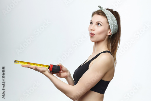 beautiful blonde girl holds a measuring tape in her hands. measurement concept about penis size