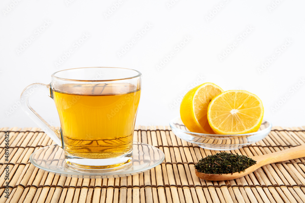 Green tea cup,lemon,wooden spoon,on wooden background