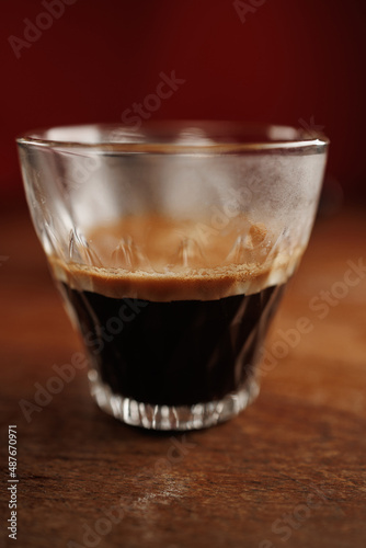 Hot cup of espresso coffee with crema on wooden table
