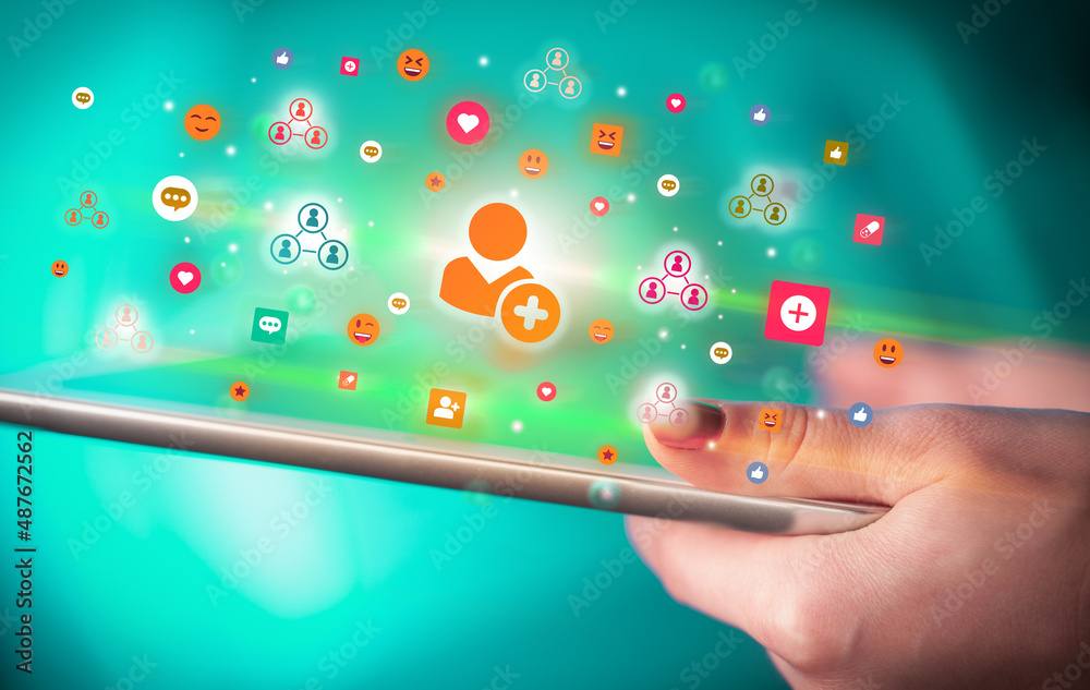 Close-up of a hand using tablet with social media icons Close-up of a hand using tablet with social media icons