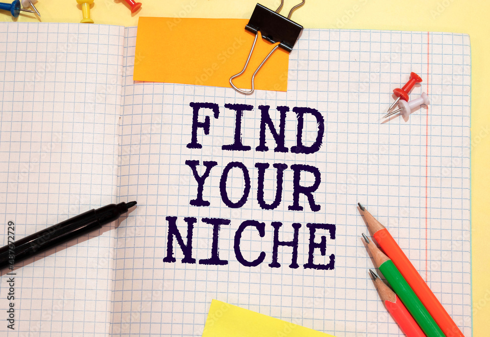 Text FIND YOUR NICHE on the short note with pencils on gray background Text FIND YOUR NICHE on the short note with pencils on gray background