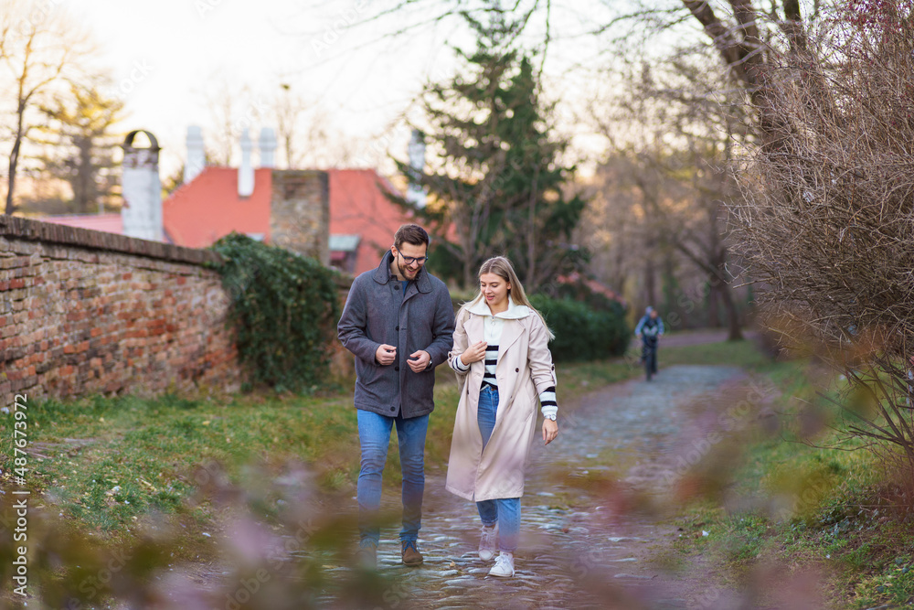 A portrait of a happy romantic couple walking outdoors in the surroundings of an old fortress A portrait of a happy romantic couple walking outdoors in the surroundings of an old fortress