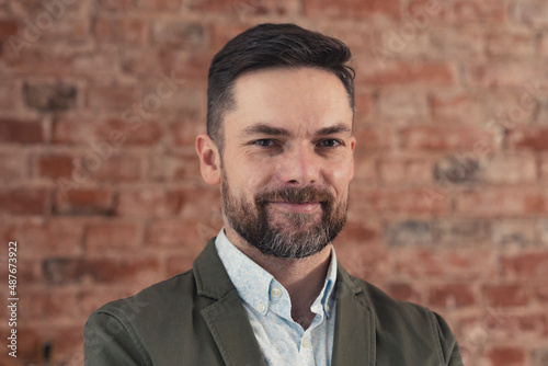 confident caucasian bearded businessman in a suit, smiling self-assured, medium close up shot. High quality photo