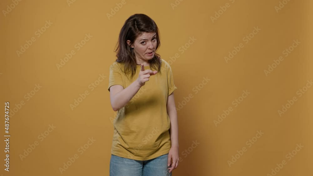 Angry upset woman arguing showing index finger pointing at guilty person punishing mischief in studio. Shouting girl looking unhappy and displeased asking for obedience and demanding respect. Angry upset woman arguing showing index finger pointing at guilty person punishing mischief in studio. Shouting girl looking unhappy and displeased asking for obedience and demanding respect.