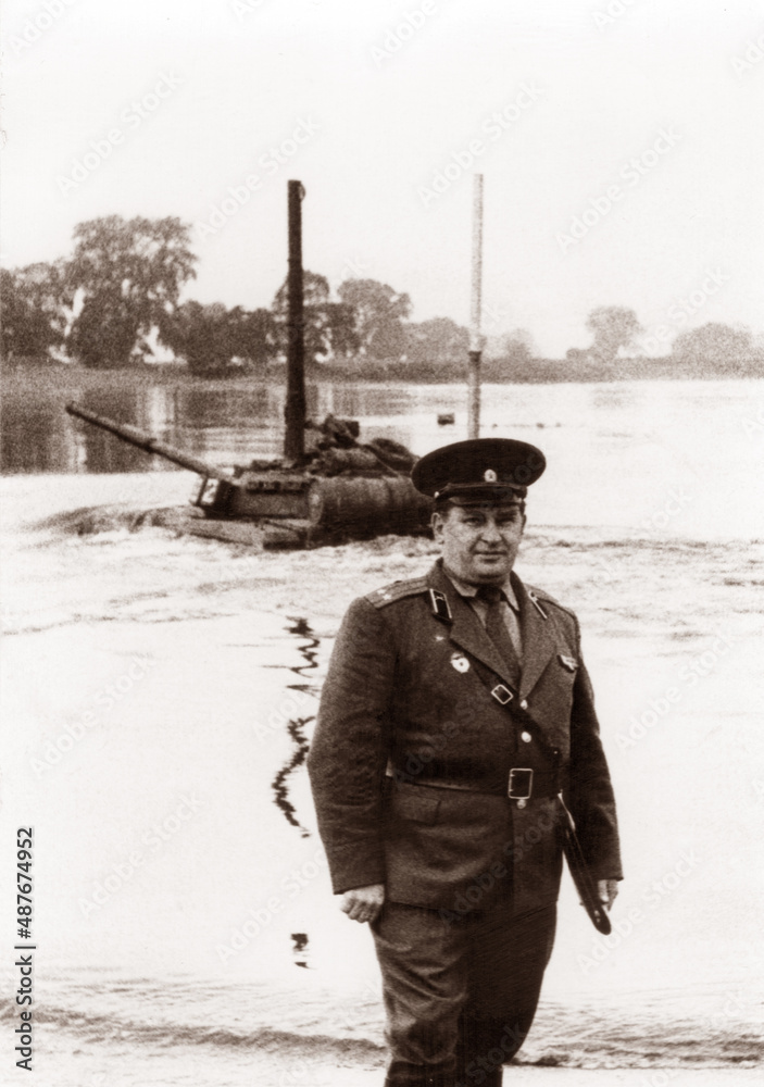 Obraz premium Photo of a lieutenant colonel of the Soviet army at military tank exercises. Tank T64 overcomes the water barrier. The tank rides along the bottom of the river.