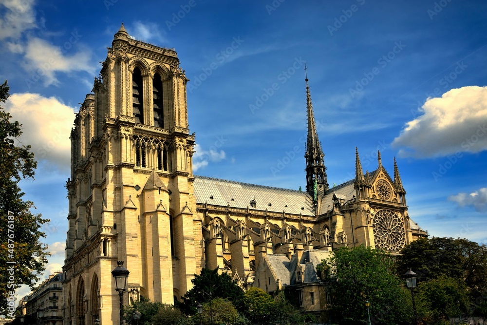 Cathedral of Notre-Dame in Paris feather clouds blue sky side view Cathedral of Notre-Dame in Paris feather clouds blue sky side view
