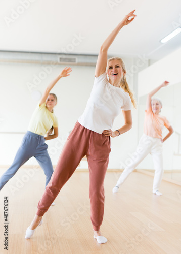 Modern positive active females dancing excited posing in studio