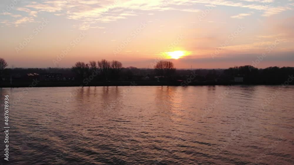 Aerial Over Orange Sunset Skies Reflected In Oude Maas In Puttershoek With Dolly Right Past Floating Buoy Aerial Over Orange Sunset Skies Reflected In Oude Maas In Puttershoek With Dolly Right Past Floating Buoy