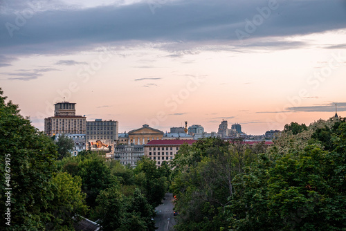 Kyiv, Ukraine. July 20, 2021. Road amidst trees in forest with cityscape and Berehynia statue in distant