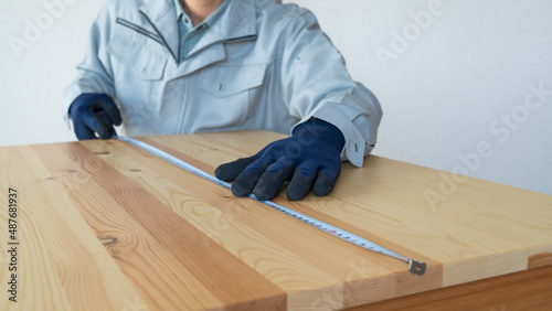 作業服の男性｜木材の寸法を測る