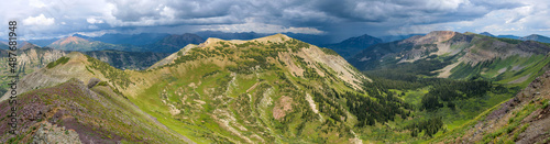 Peeler Peak - A panoramic Summer view of Peeler Peak of Elk Mountains, with dark storm clouds hovering over Mount Crested Butte in background. Crested Butte, Colorado, USA. 