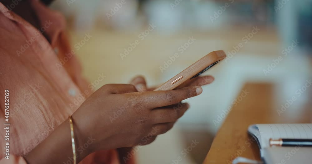 Beautiful young black woman texting on her mobile phone in coffee shop Beautiful young black woman texting on her mobile phone in coffee shop