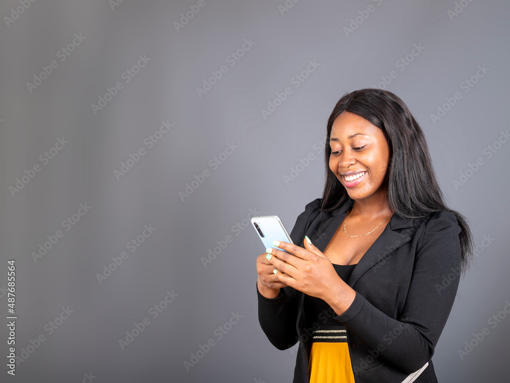 Happy nice african businesswoman using cellphone isolated over grey background Happy nice african businesswoman using cellphone isolated over grey background