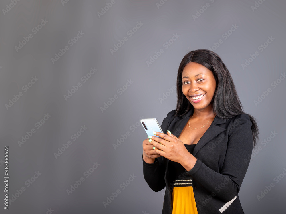 smiling young Black woman wear black suit using smartphone app isolated on grey studio background copy space smiling young Black woman wear black suit using smartphone app isolated on grey studio background copy space